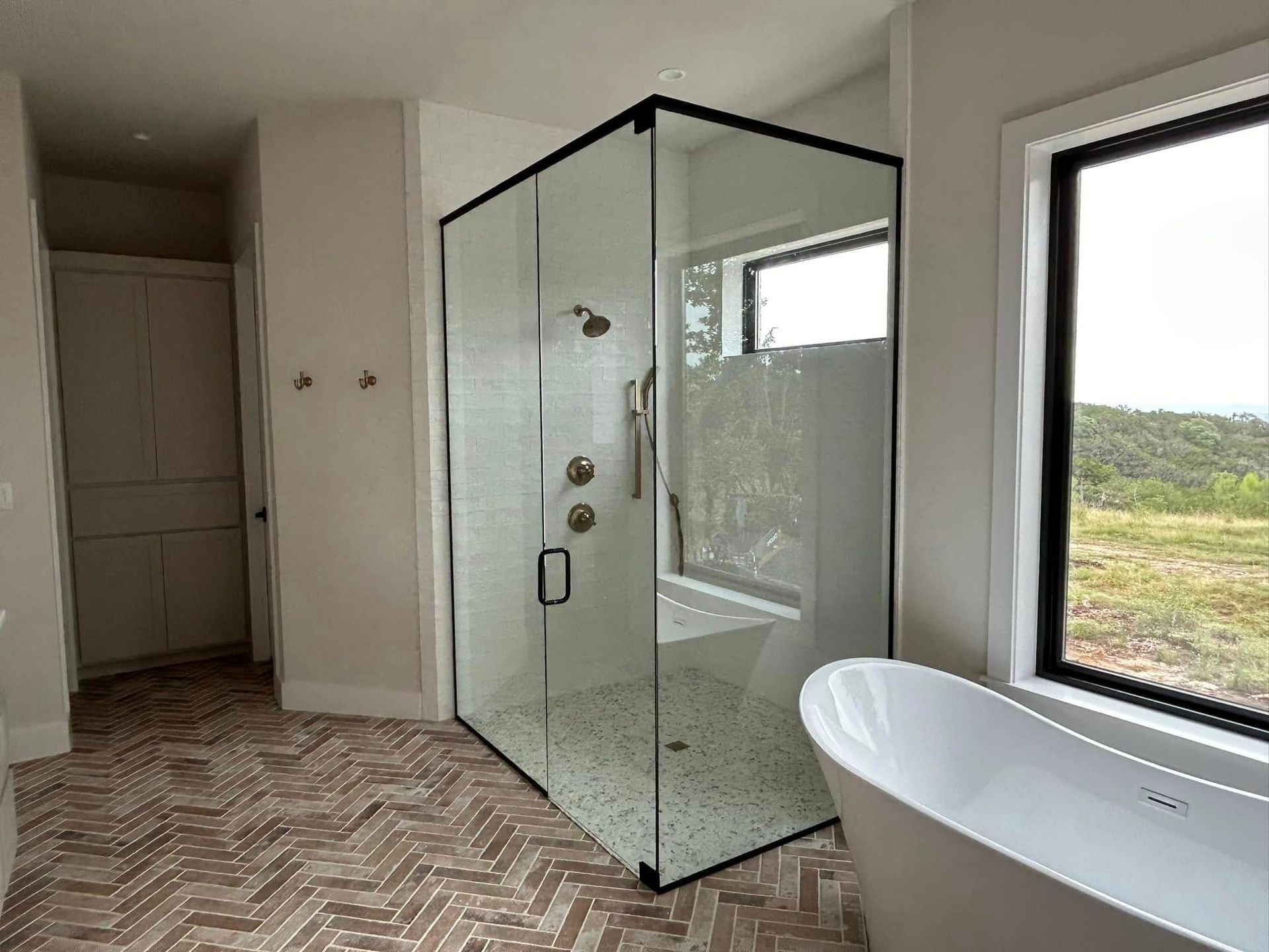 A bathroom with a walk in shower and a bathtub.