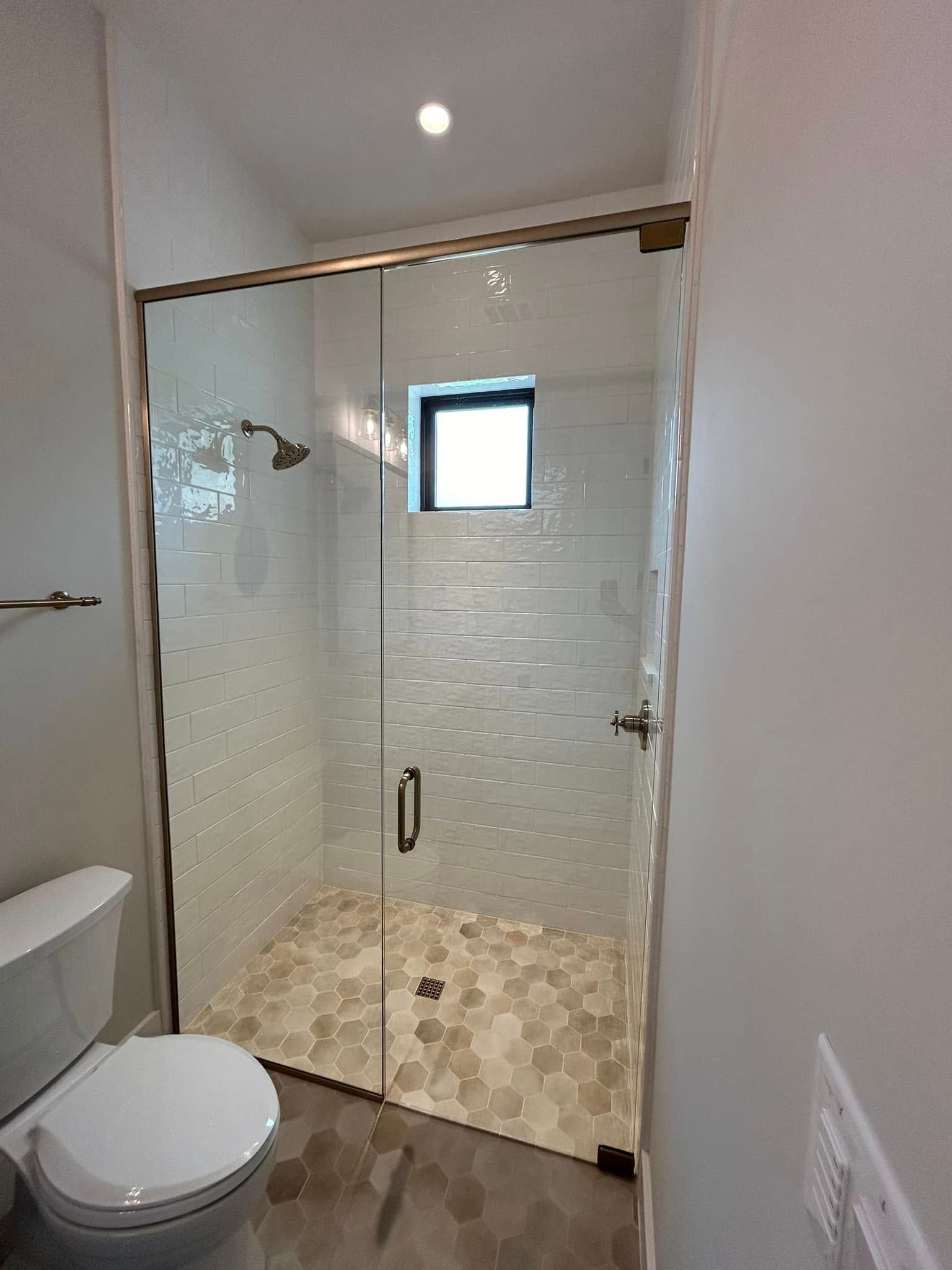 A bathroom with a toilet and a shower with a glass door.