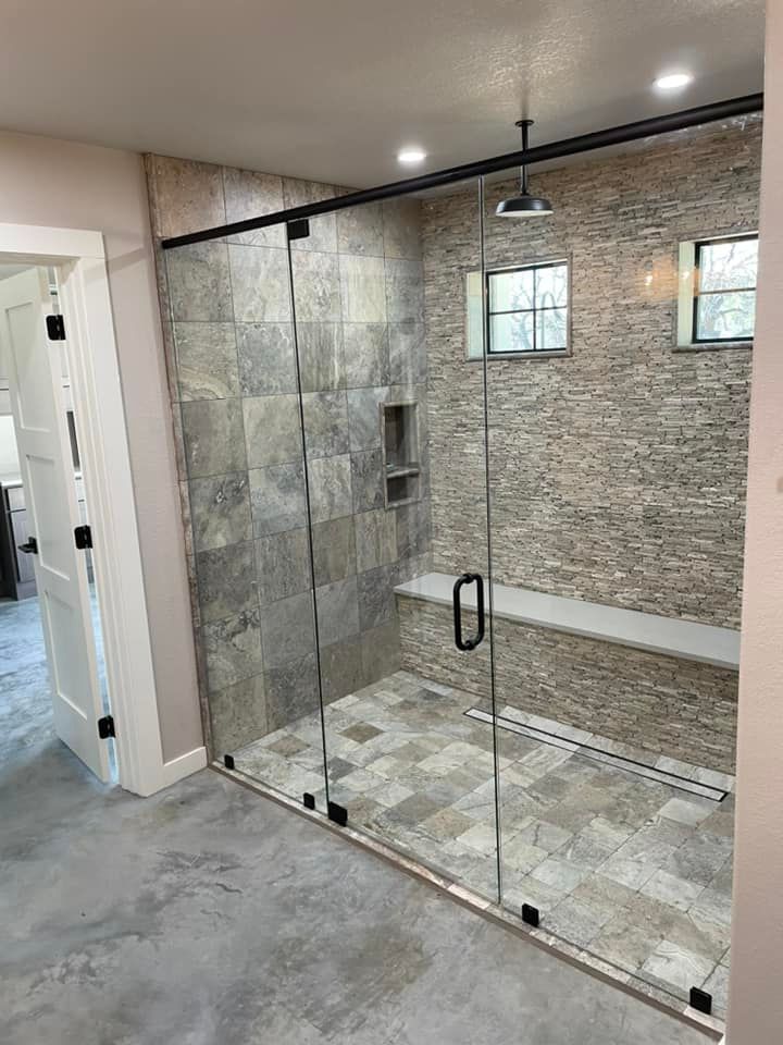 A bathroom with a walk in shower with sliding glass doors.
