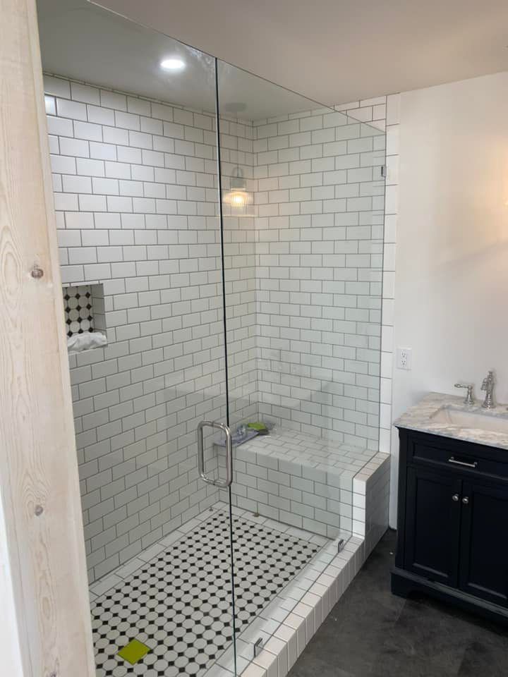 A bathroom with a walk in shower and a sink.