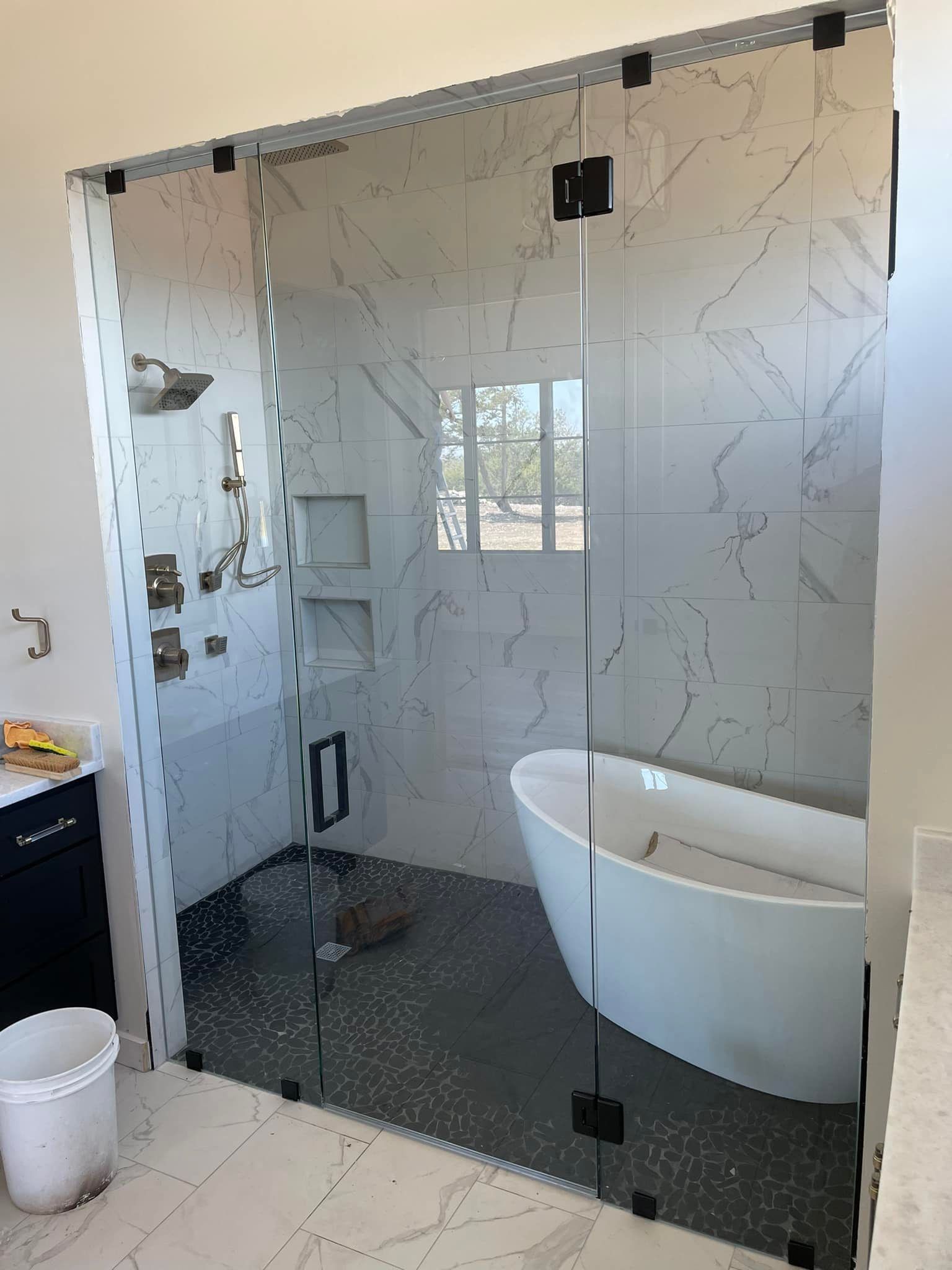 A bathroom with a walk in shower and a bathtub.