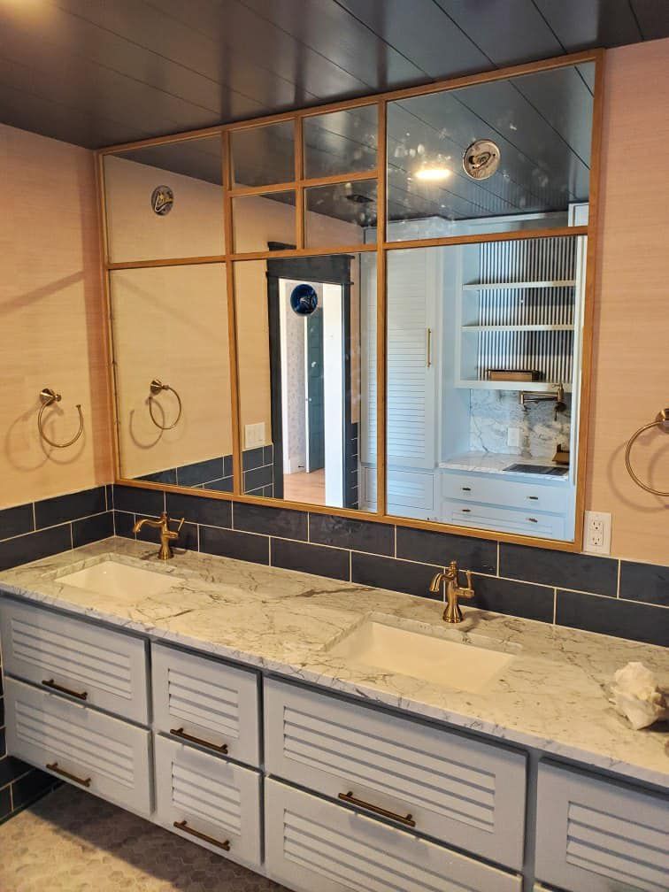 A bathroom with two sinks and a large mirror.