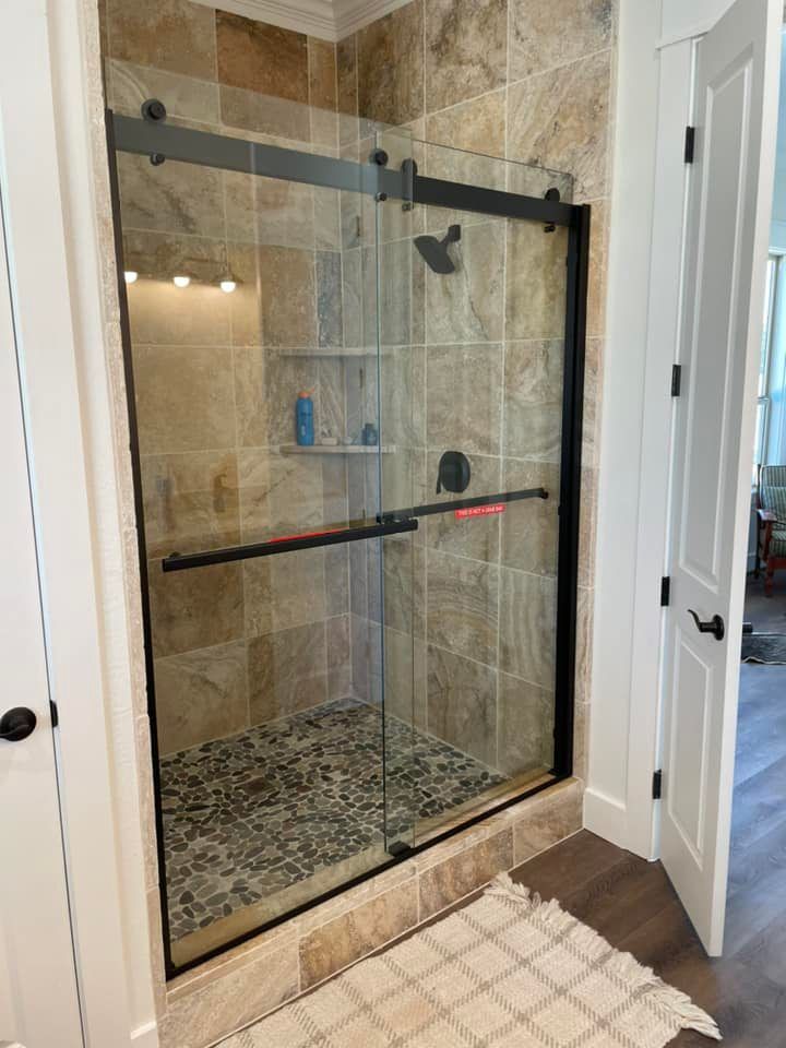A bathroom with a sliding glass shower door.