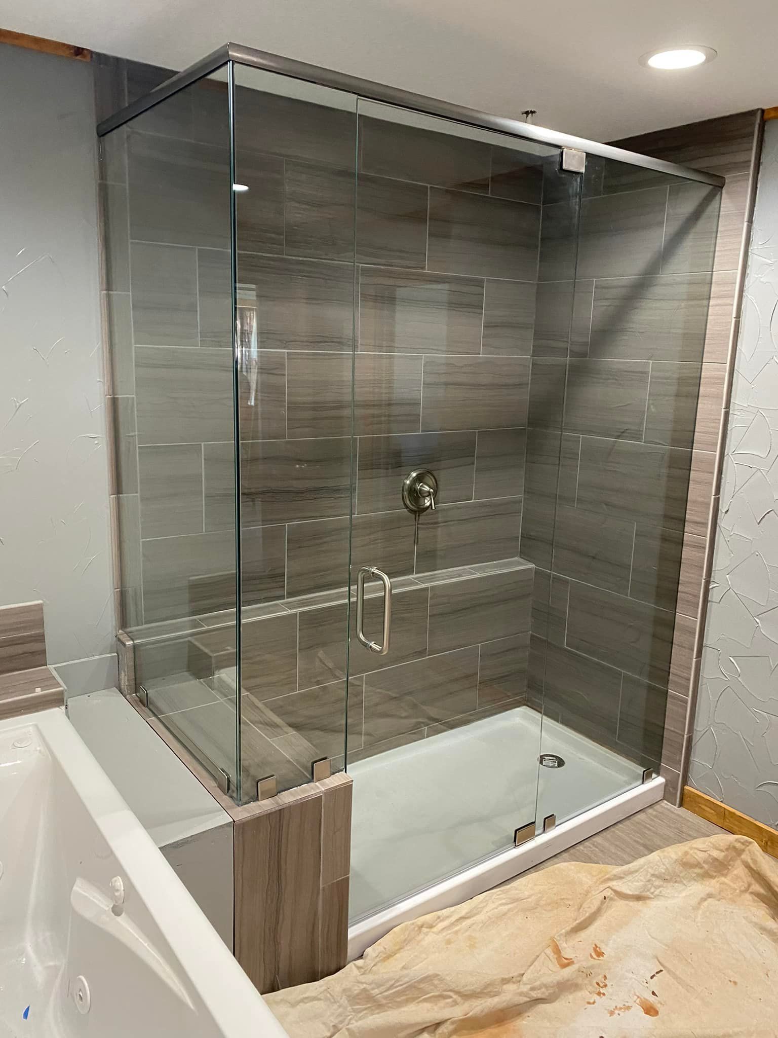 A bathroom with a walk in shower and a bathtub.