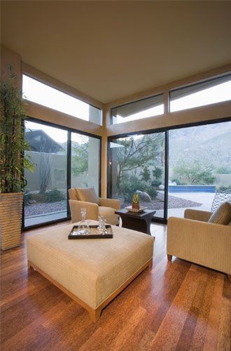 A living room with sliding glass doors and a large ottoman