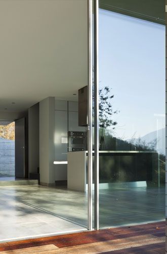 A sliding glass door is open to a kitchen and patio.
