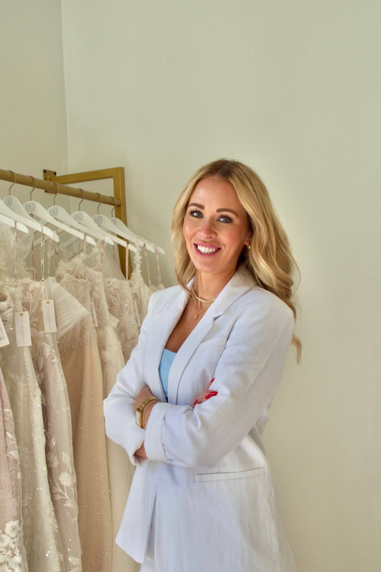 Bridal store owner in white jacket with  wedding dresses in the background
