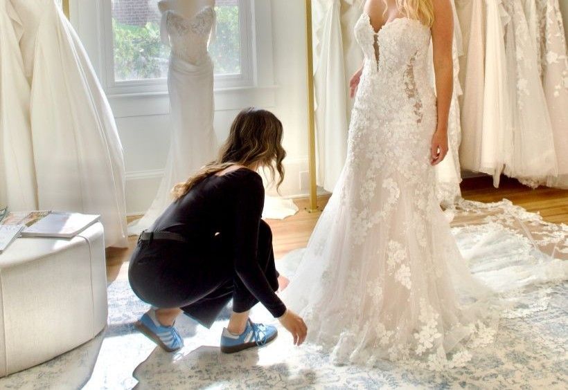A room filled with lots of wedding dresses on mannequins.