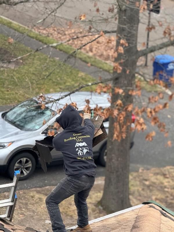 A man in a hoodie is standing on top of a roof.