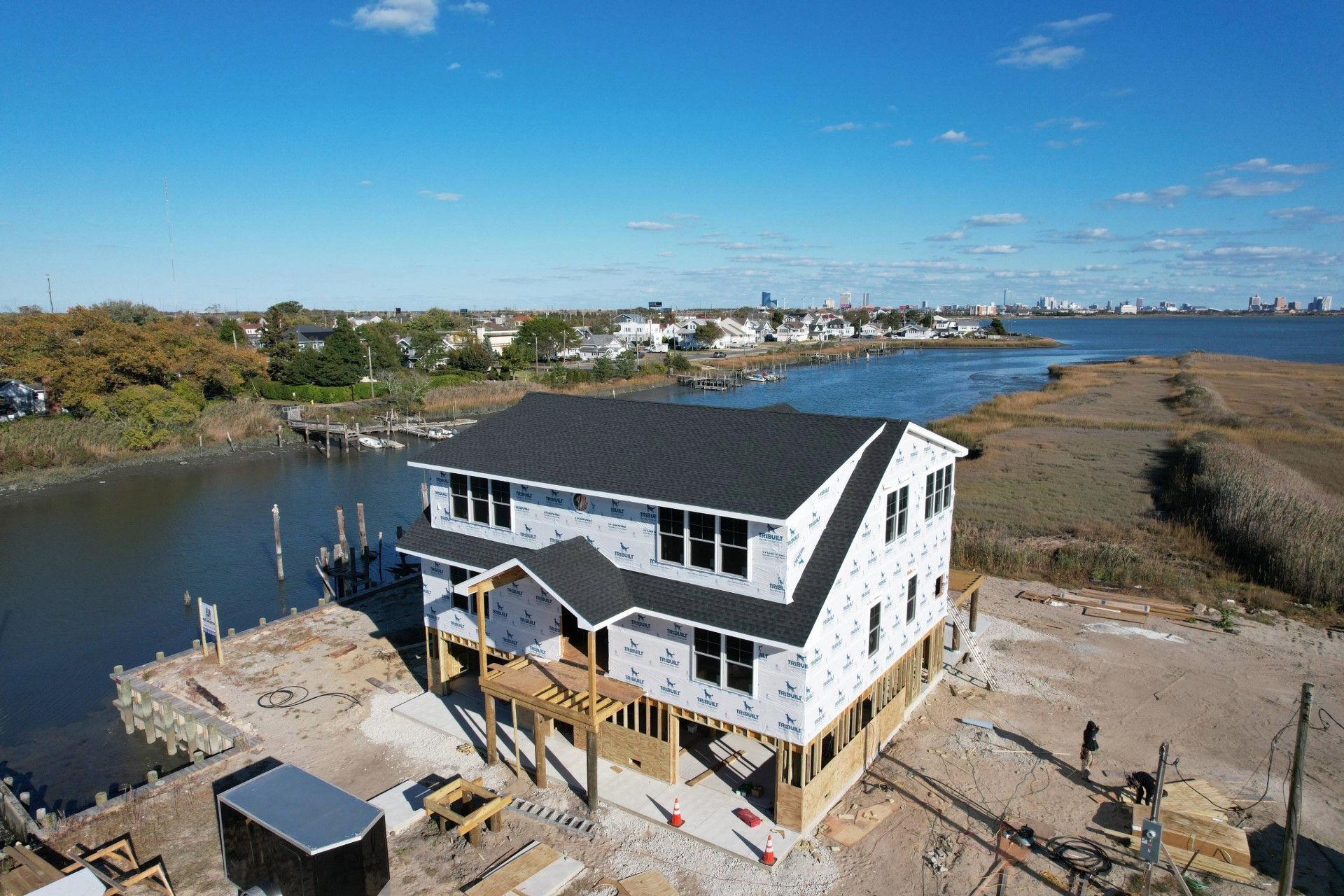 An aerial view of a house under construction next to a body of water.