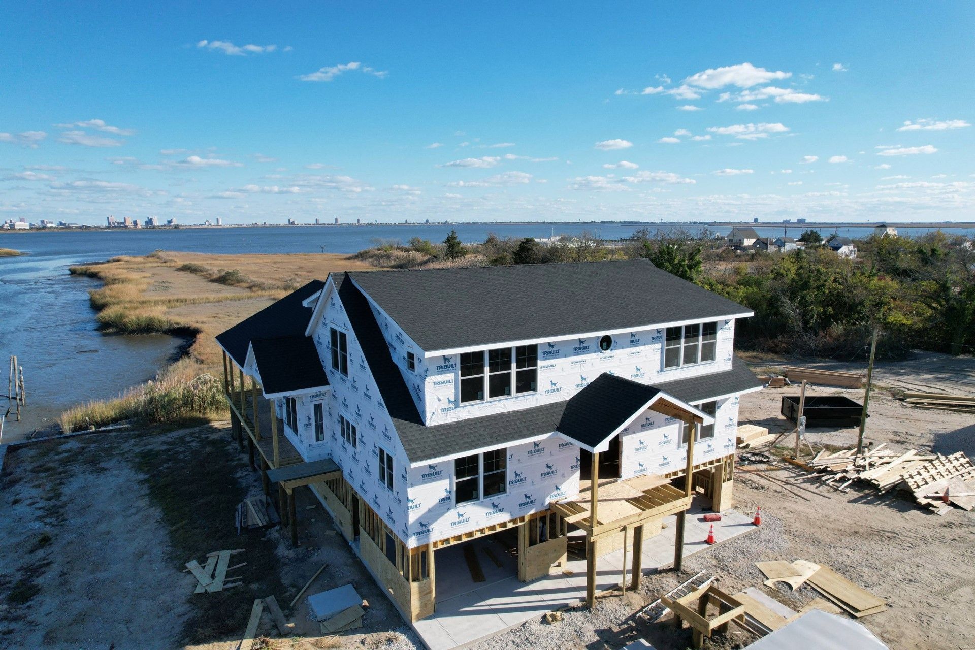 An aerial view of a house under construction next to a body of water.