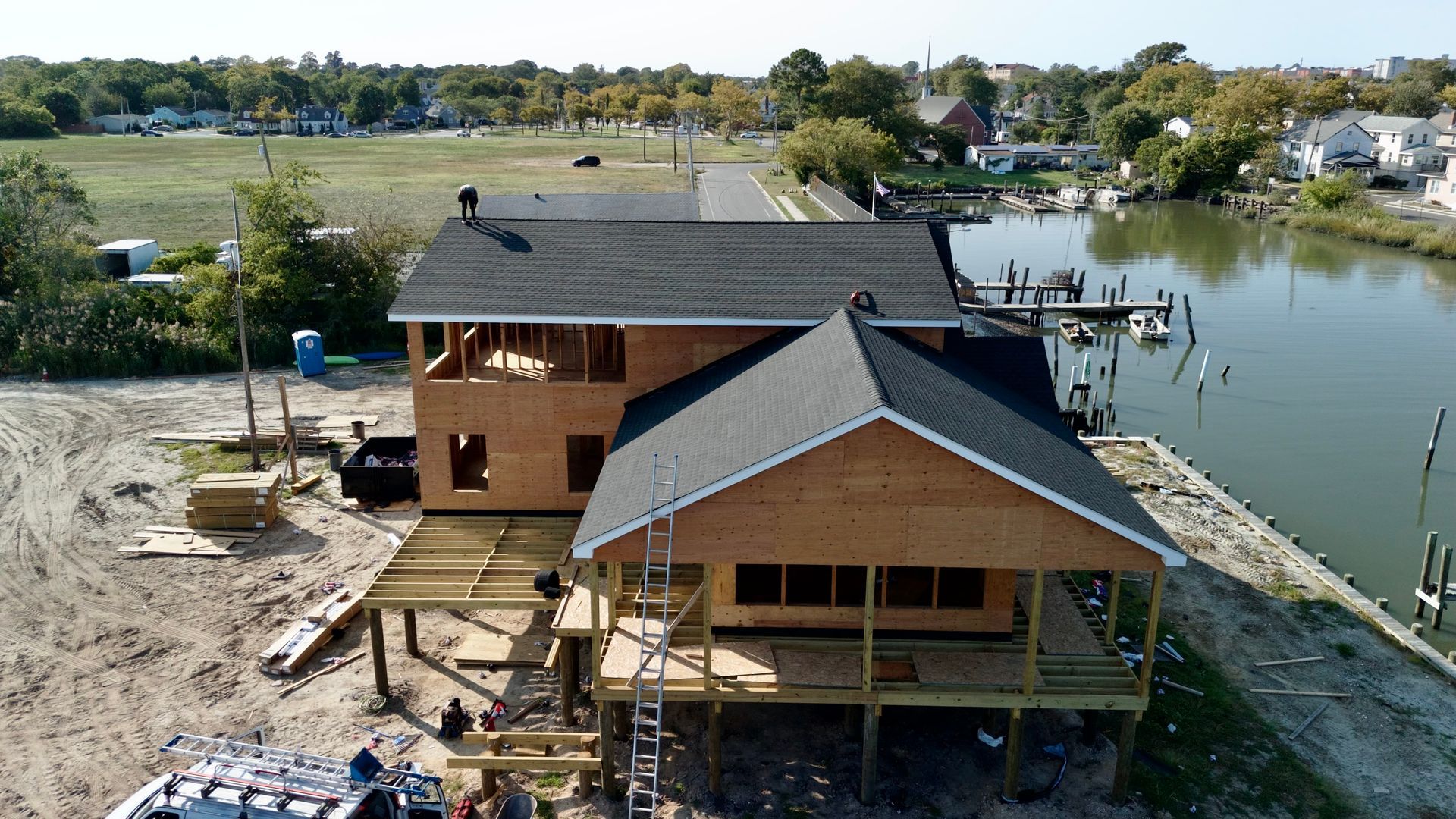 An aerial view of a house under construction next to a body of water