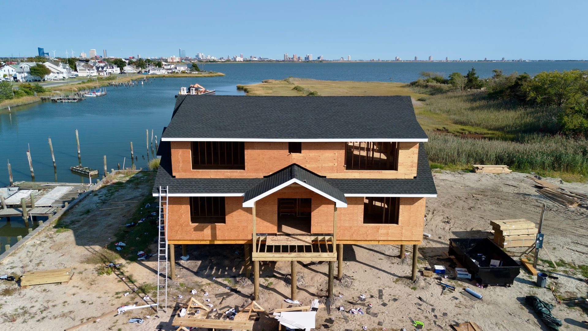 An aerial view of a house under construction next to a body of water.