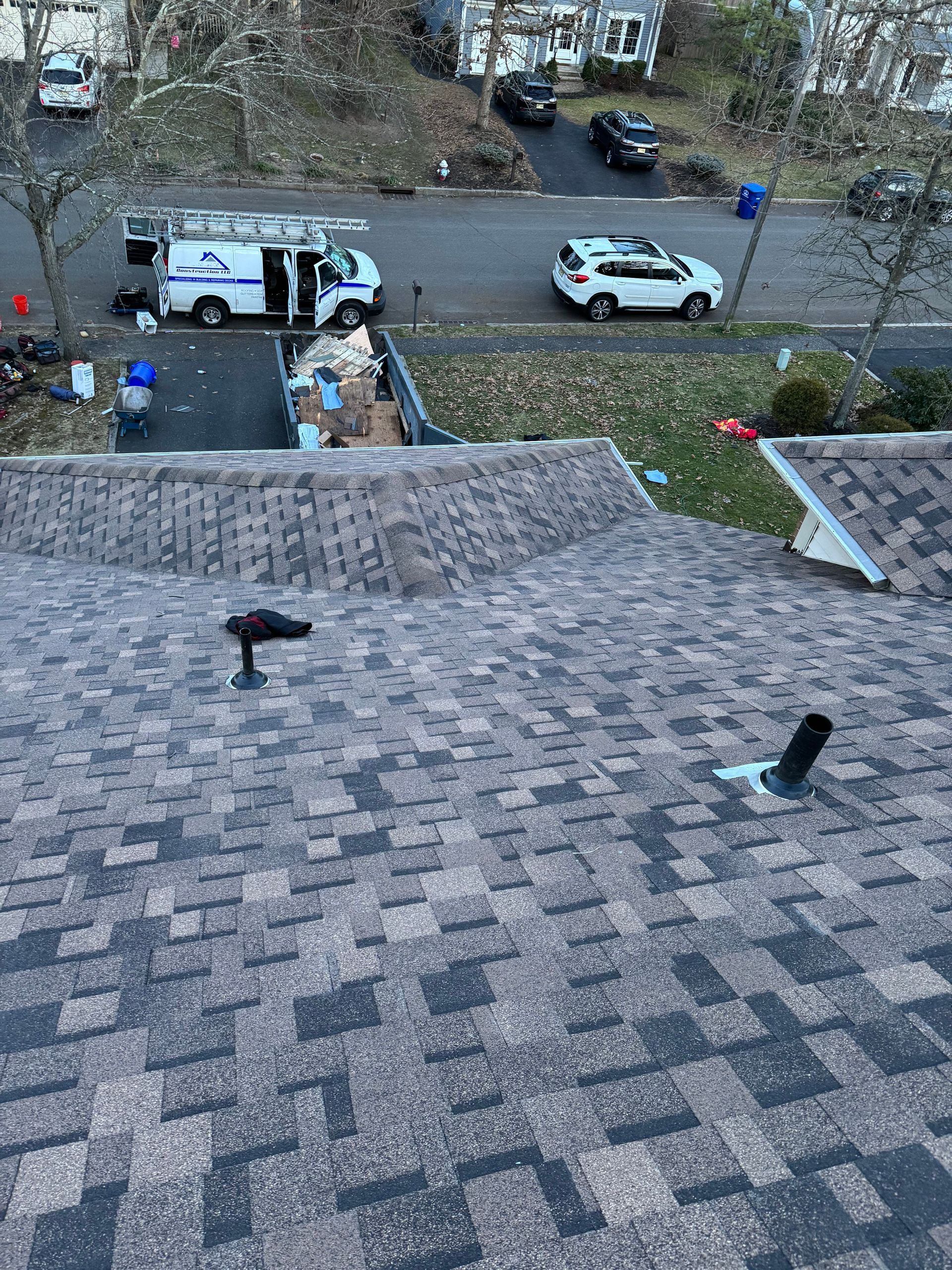 An aerial view of a roof with a van parked in the background.