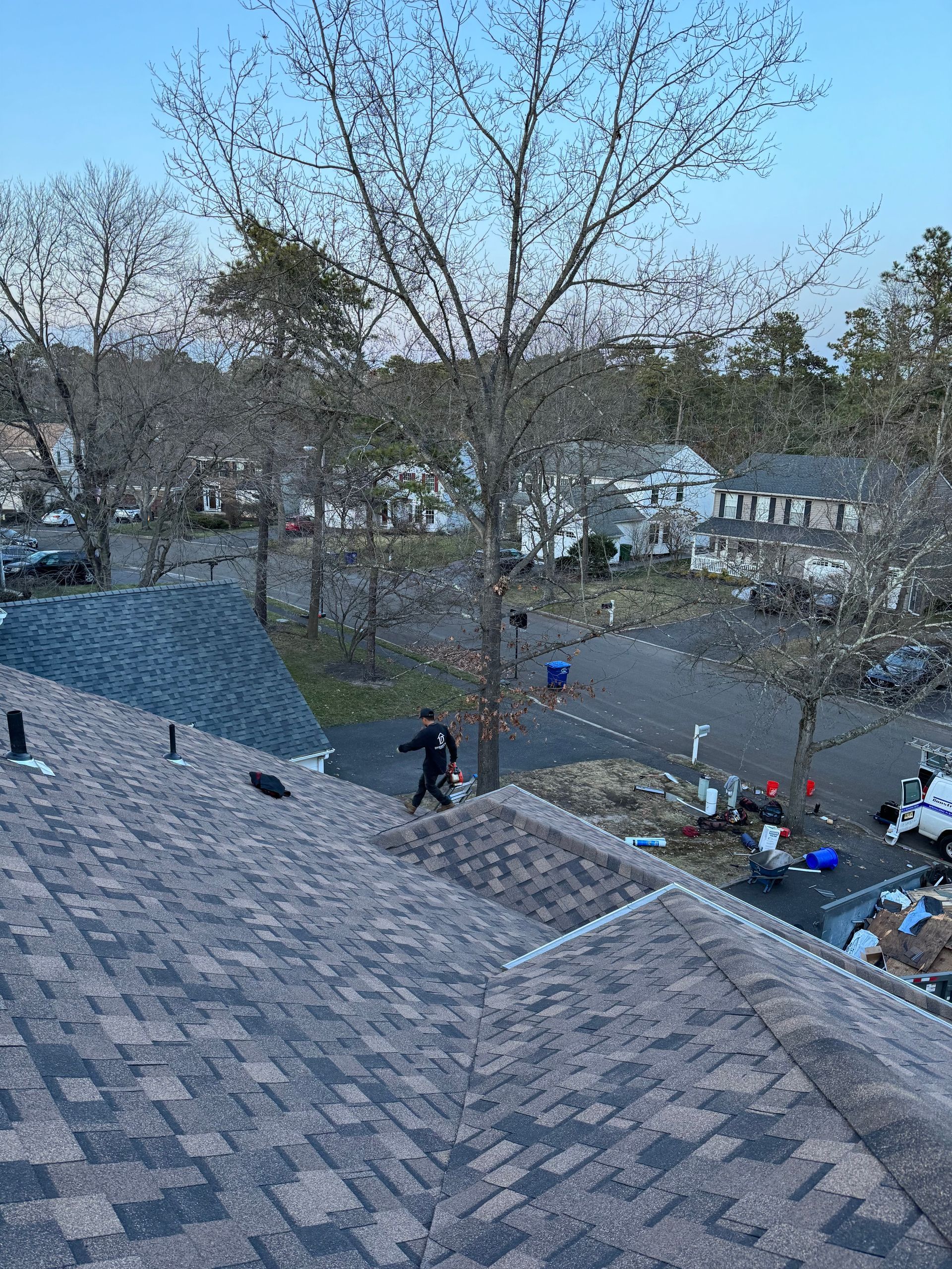 A group of people are working on the roof of a house.