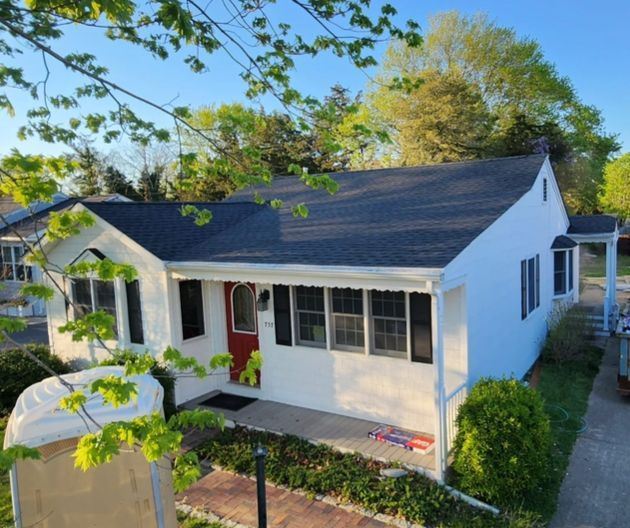 A white house with black shutters and a red door