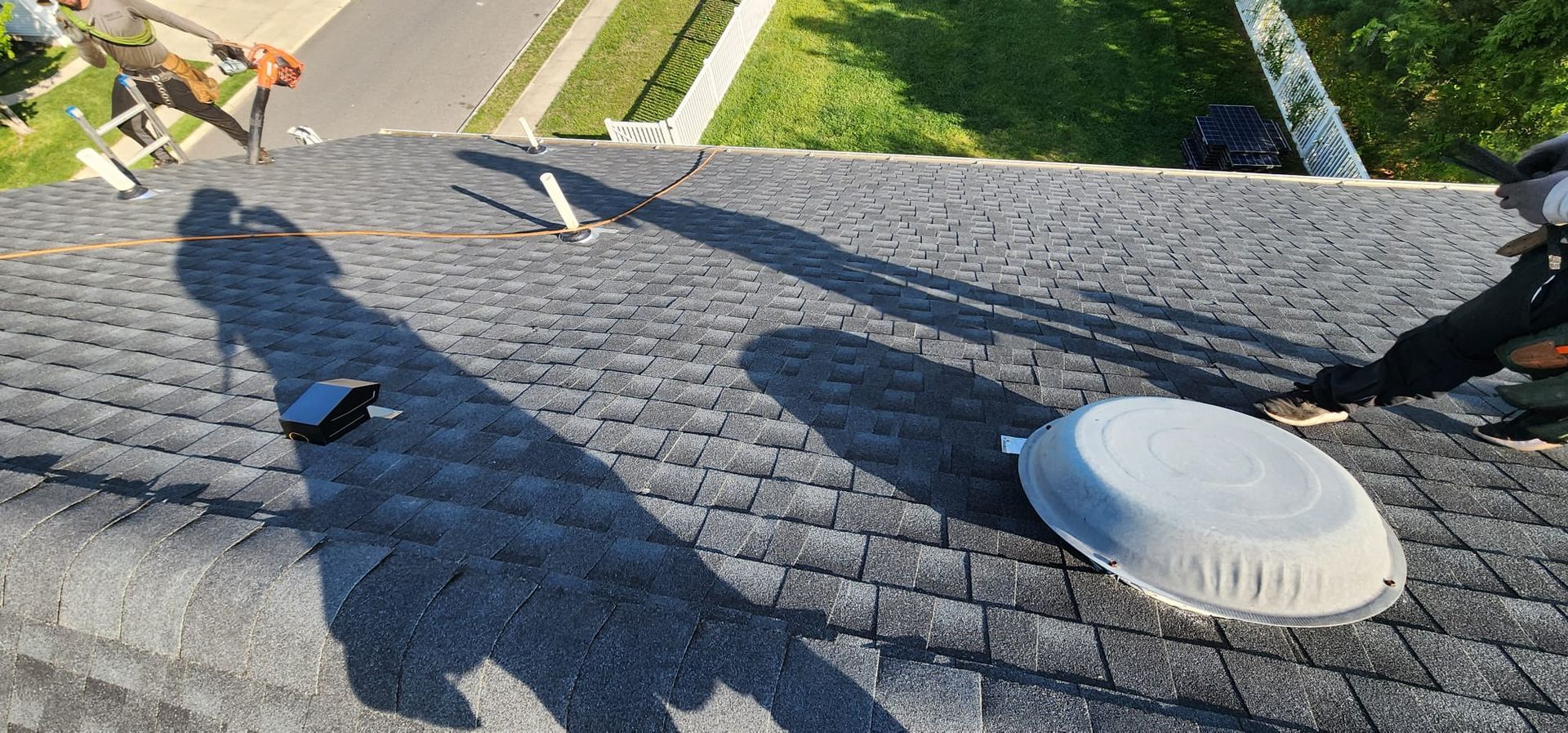 A man is working on the roof of a house.