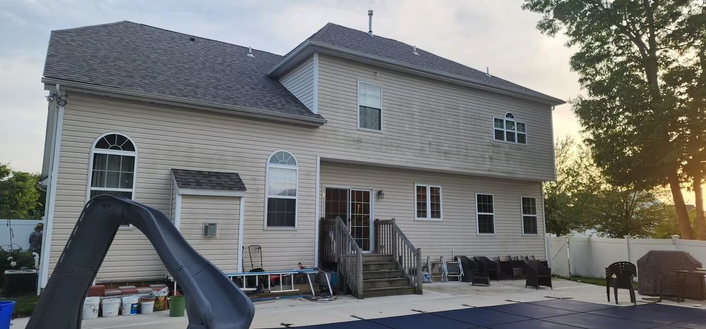 A large white house with a slide in the backyard.