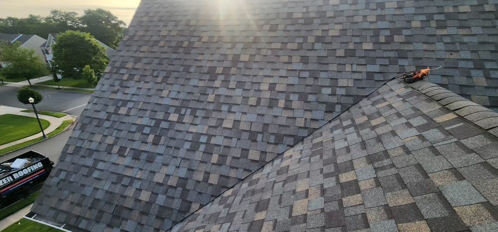 A roof with a lot of shingles on it and a car parked in front of it.
