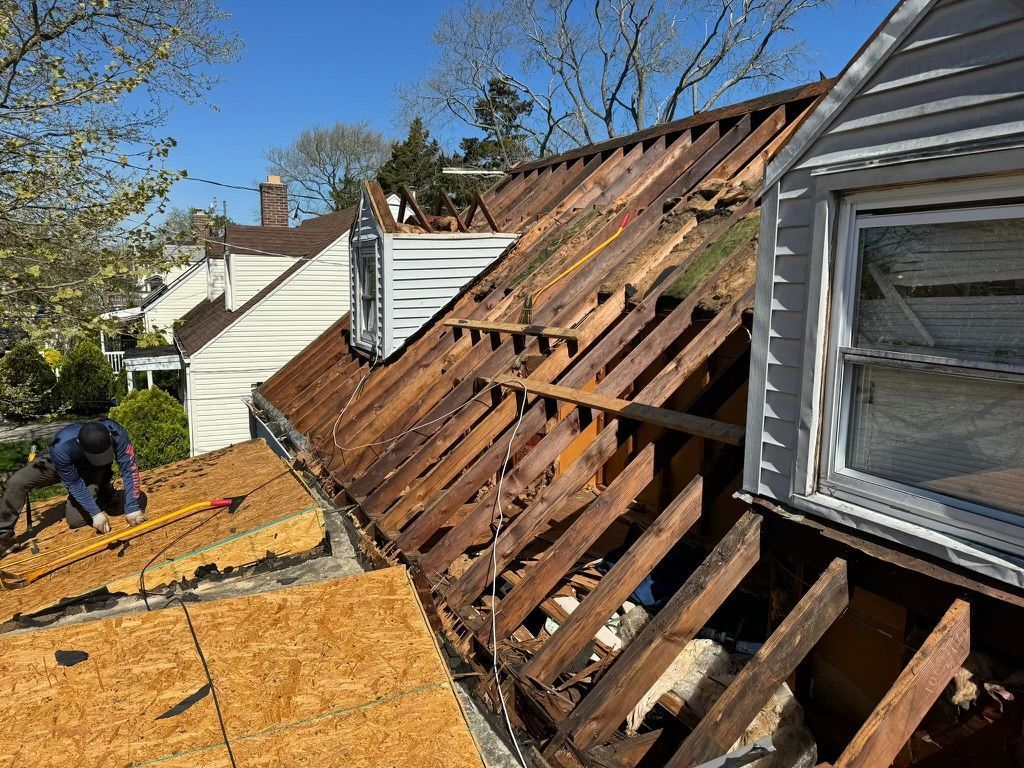 A man is working on the roof of a house.