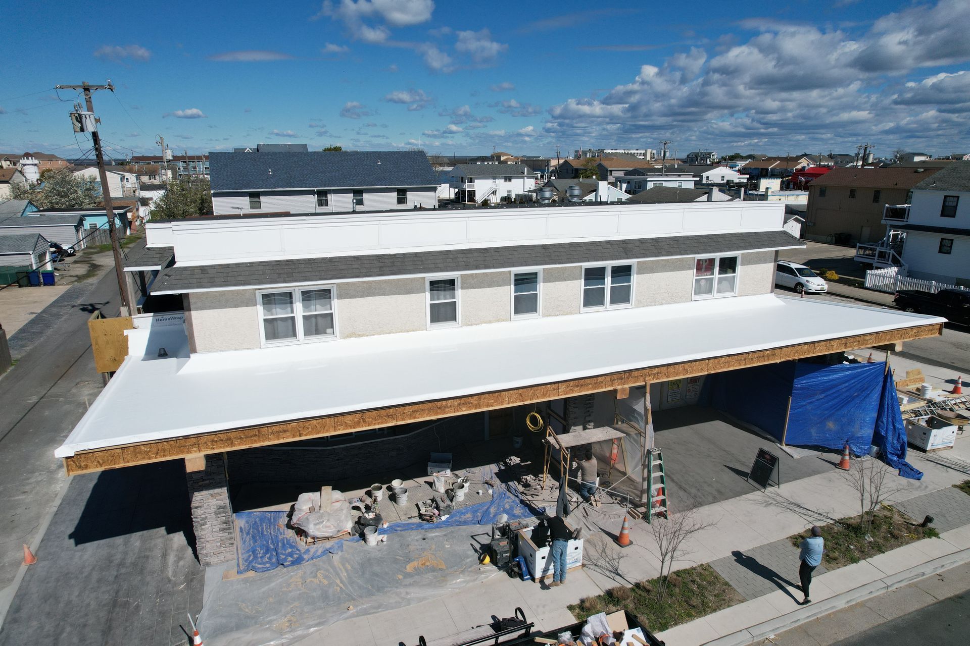 An aerial view of a building under construction with a white roof