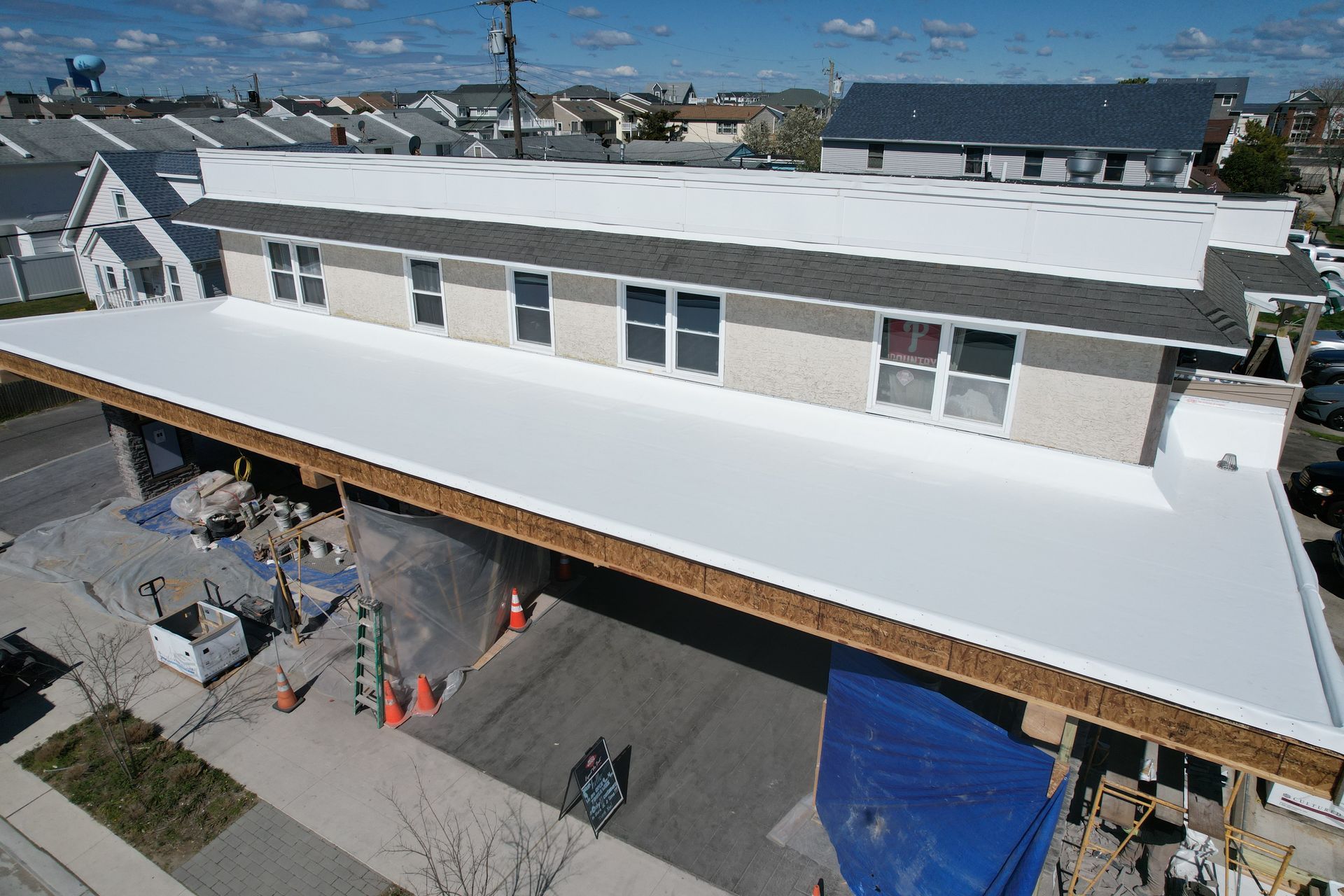 An aerial view of a building under construction with a white roof.