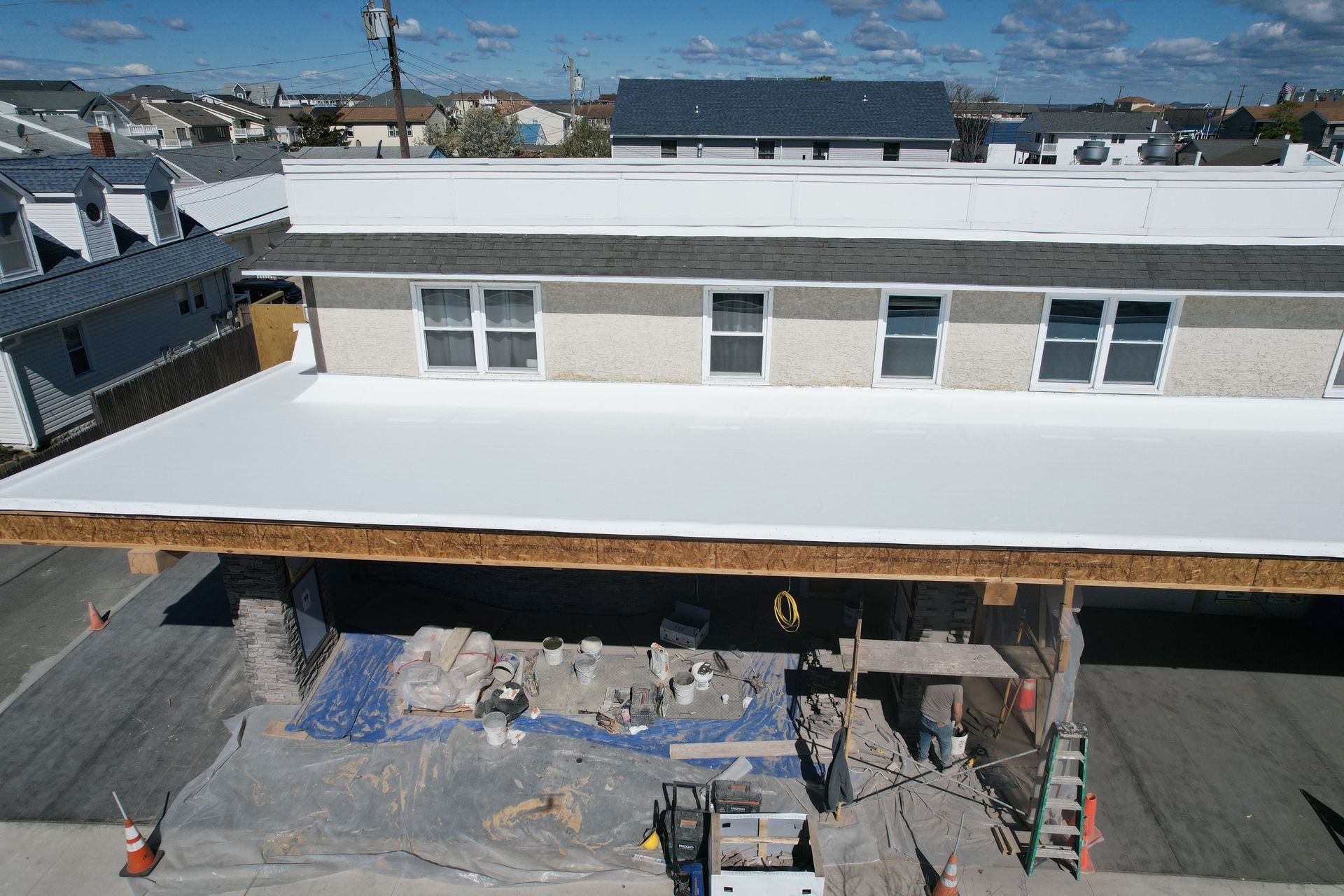 An aerial view of a building under construction with a white roof.