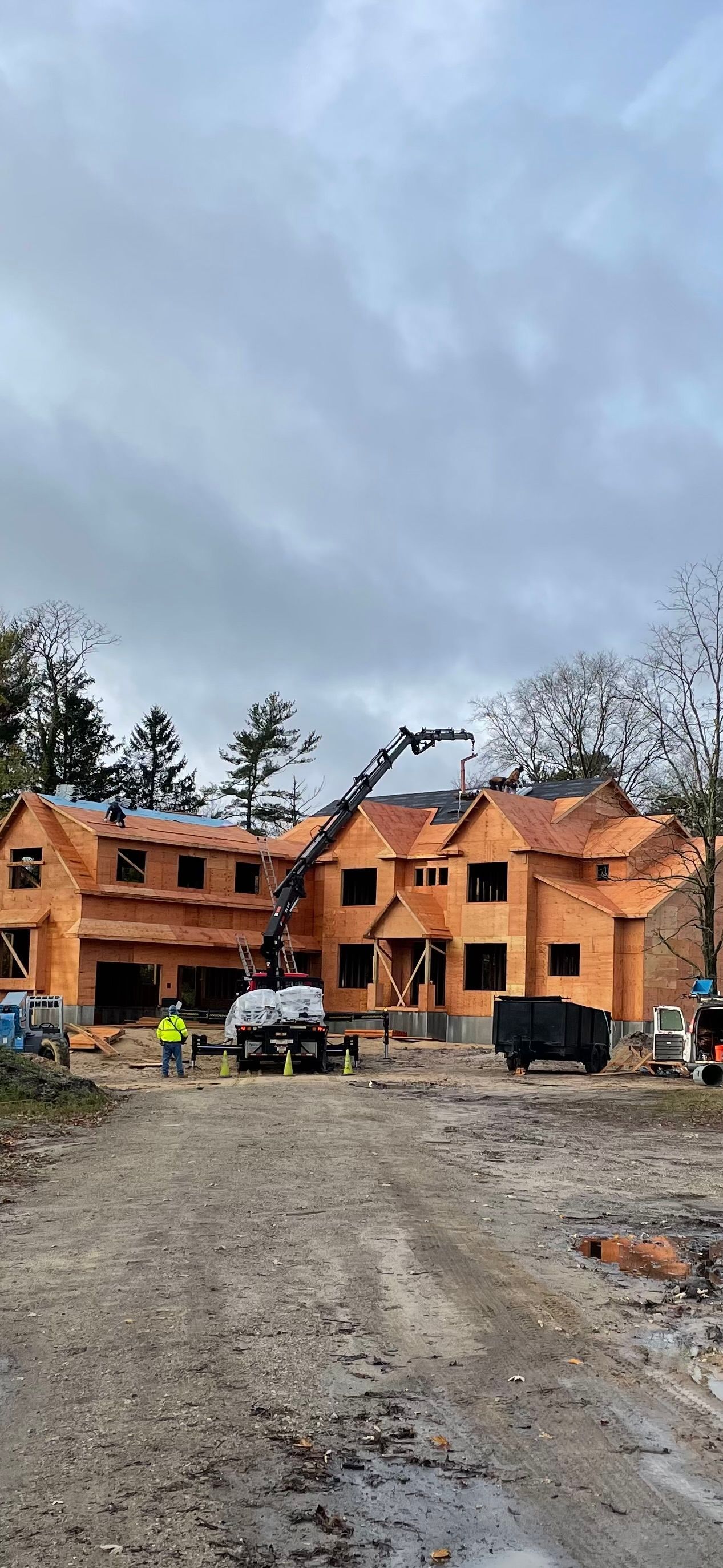 A large house is being built on a dirt road.