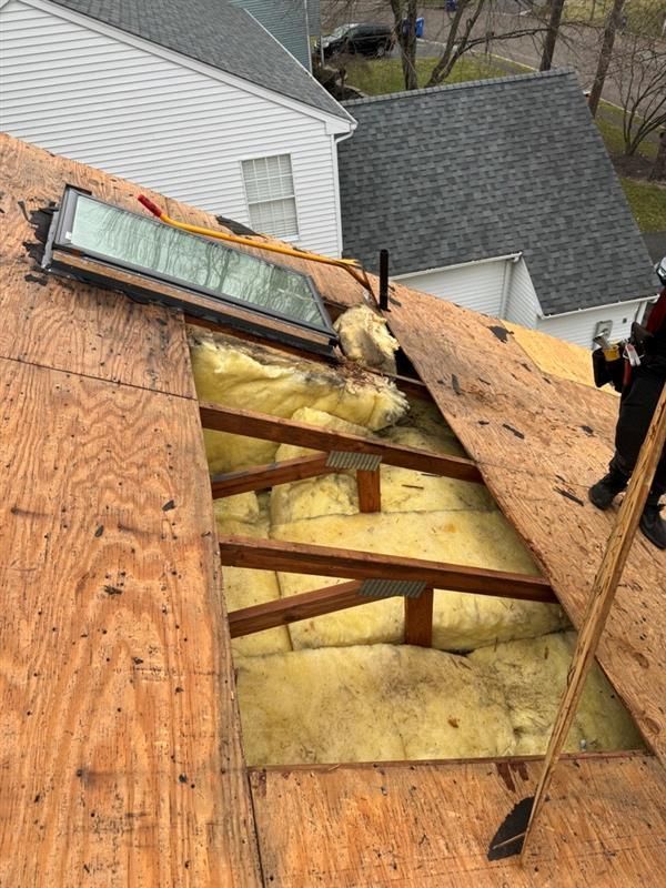 A man is working on the roof of a house.