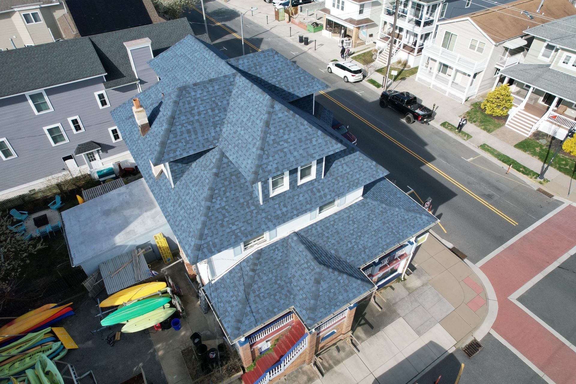 An aerial view of a building with a blue roof and kayaks in front of it.