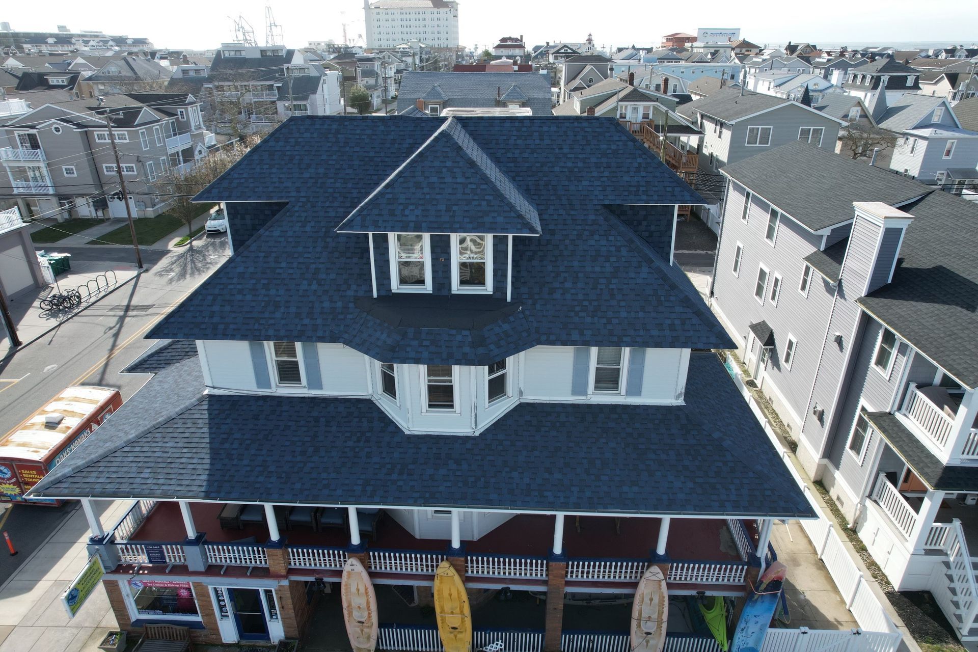 An aerial view of a large house with a black roof