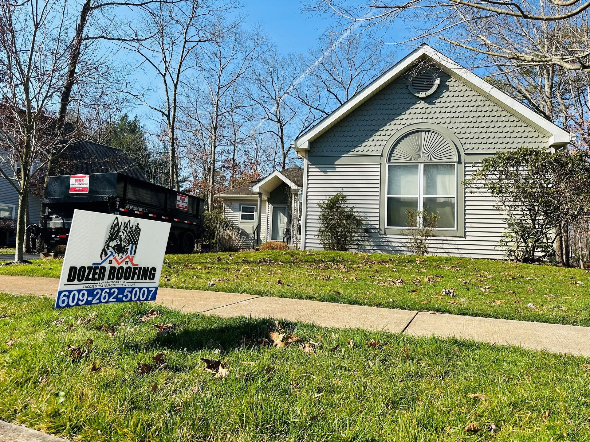 A house with a for sale sign in front of it.