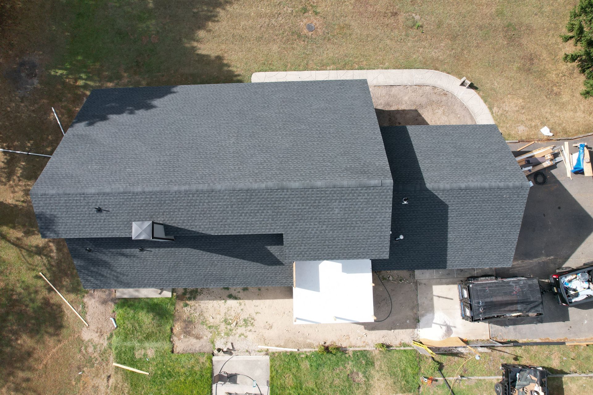 An aerial view of a house with a black truck parked in front of it.