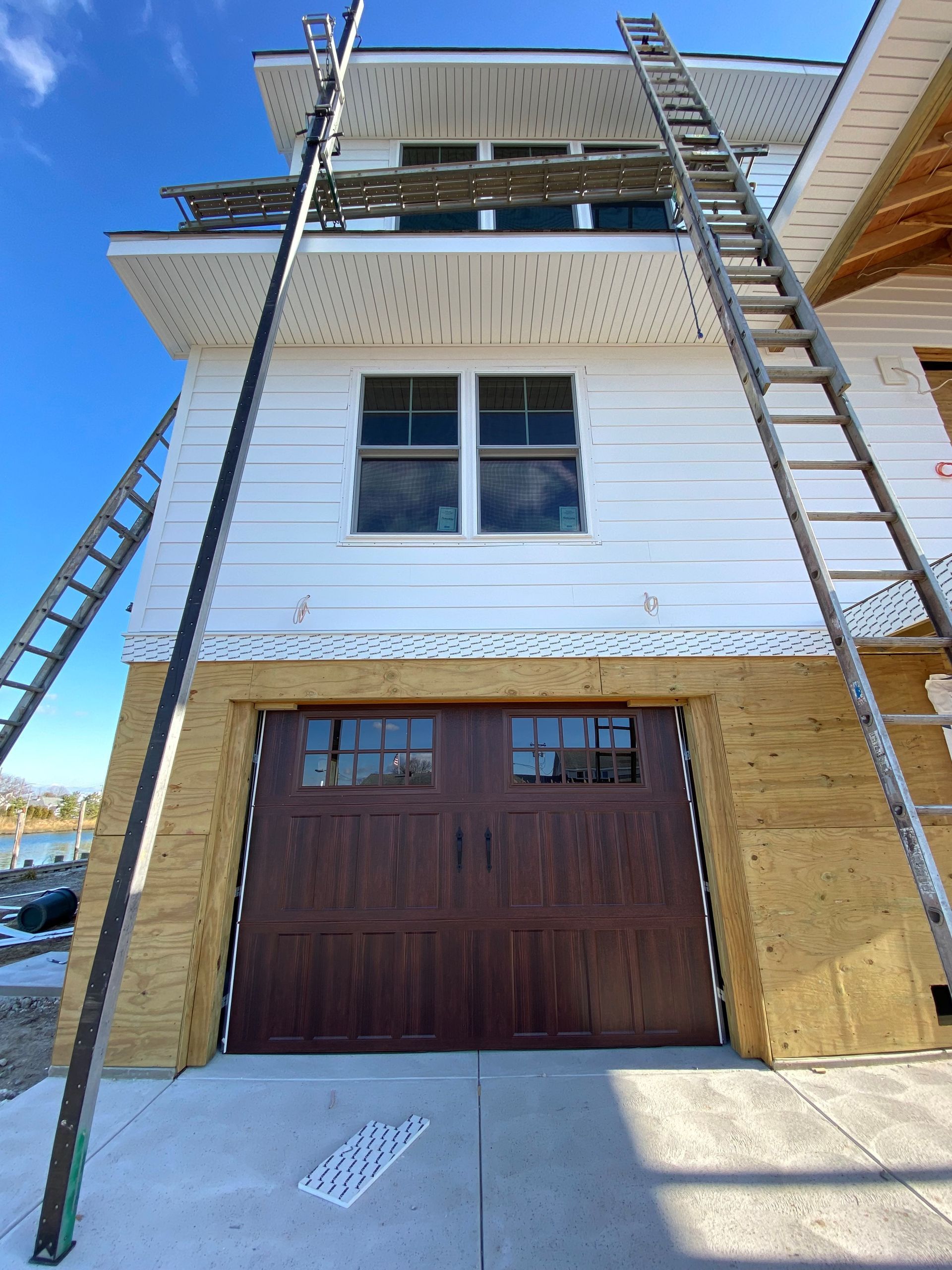 A white house with a brown garage door under construction