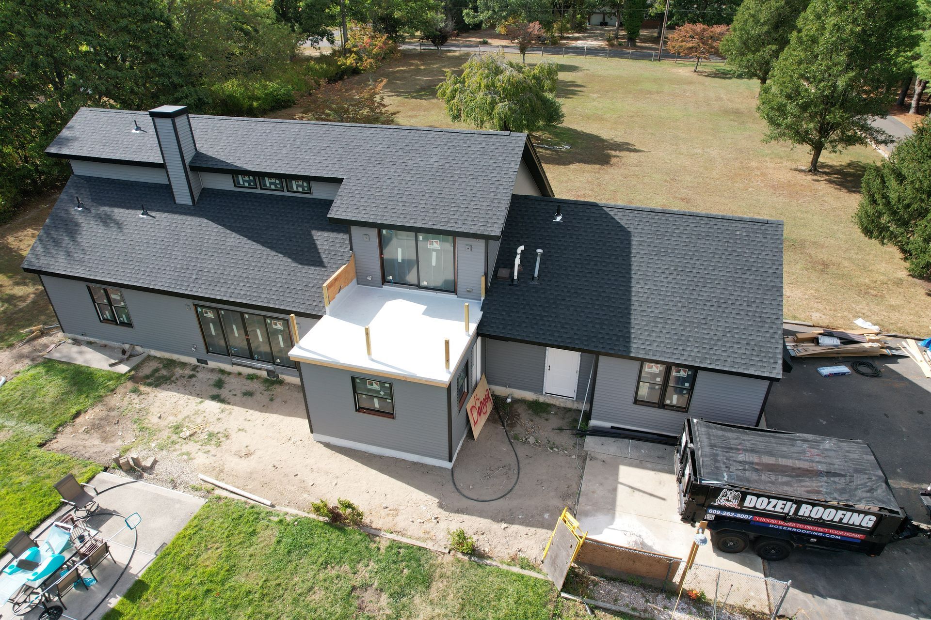 An aerial view of a house under construction with a dumpster in front of it.