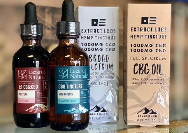 Two CBD tincture bottles and two product boxes from Lazarus Naturals on a white surface
