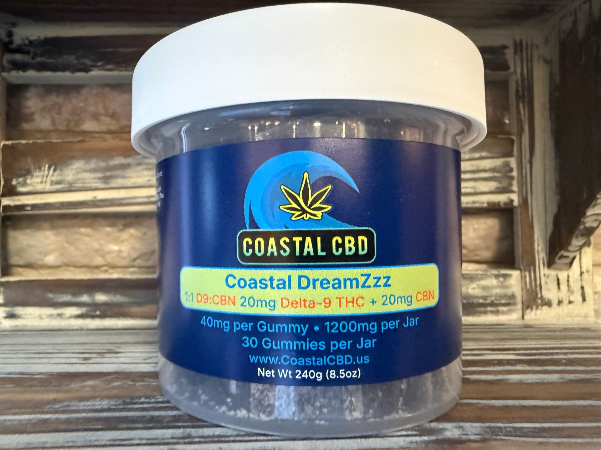 Blue Coastal CBD jar with white lid and colorful cannabis label on a shelf