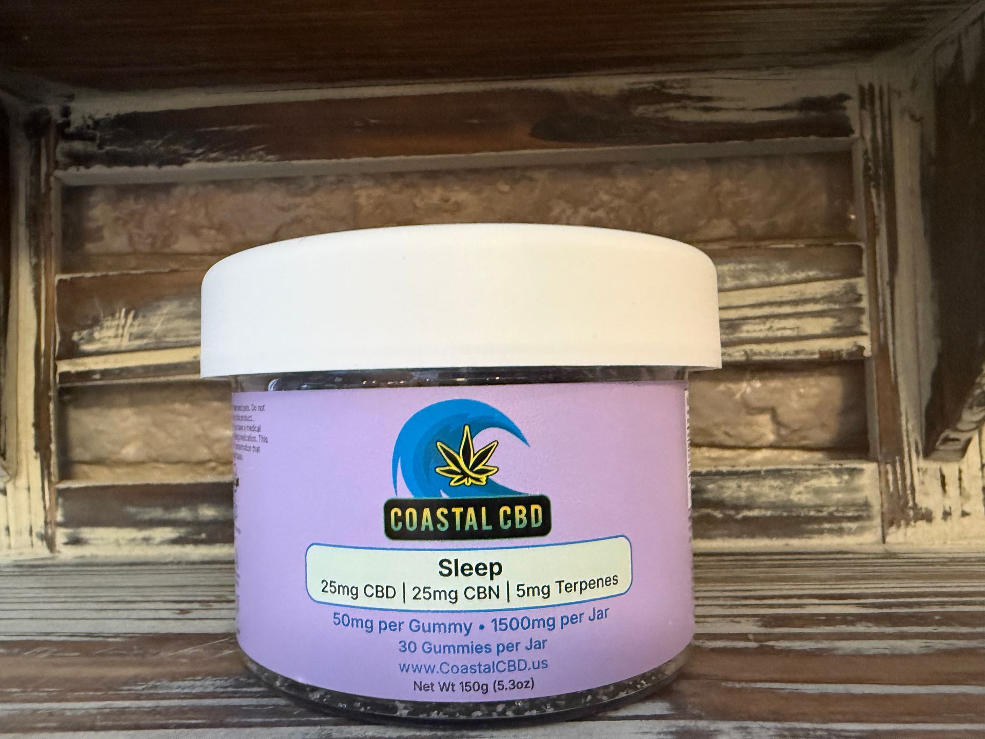 Purple CBD balm jar with white lid on rustic wooden shelf