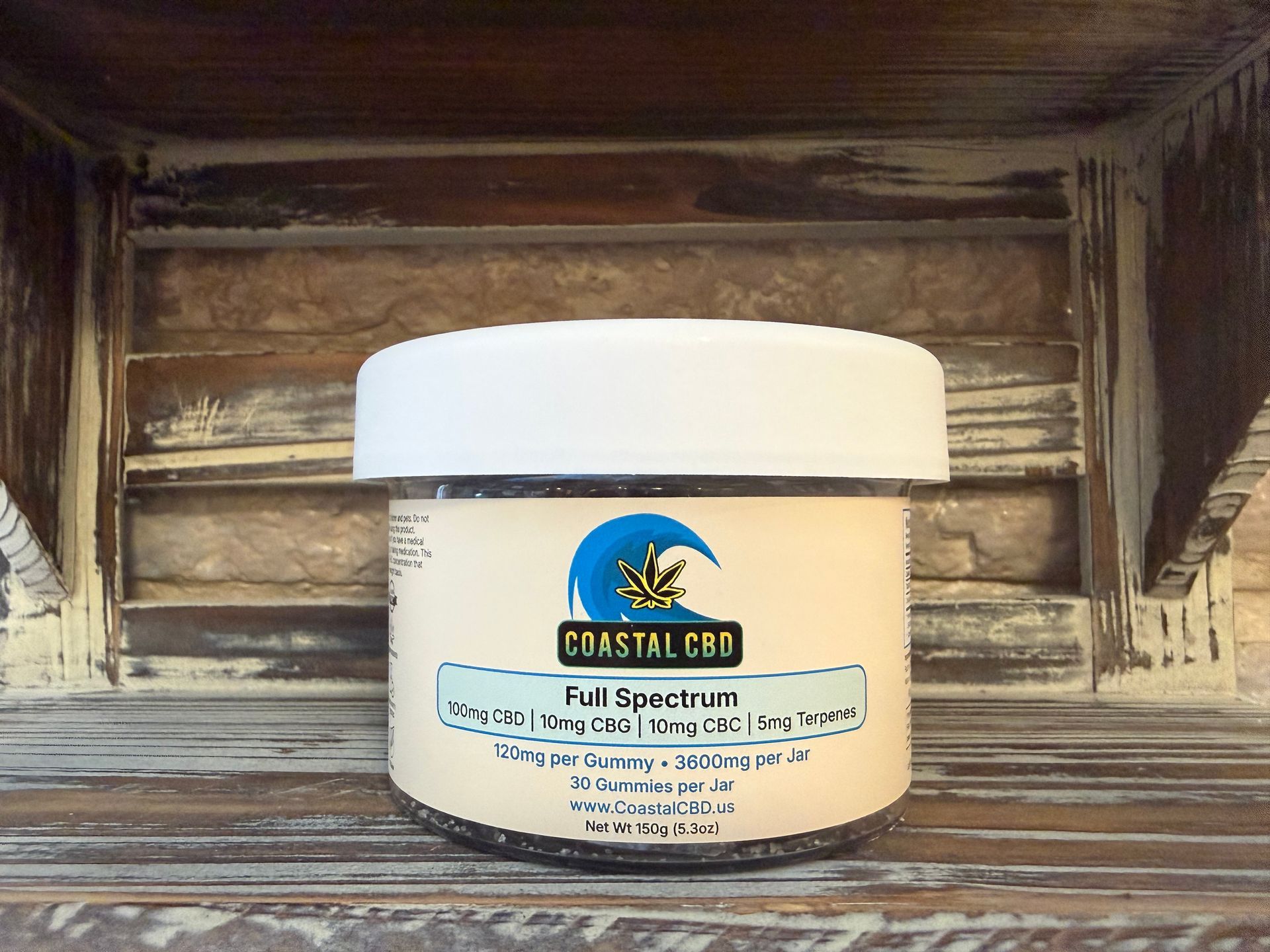 White supplement jar with blue label and palm tree logo on a rustic wooden shelf.