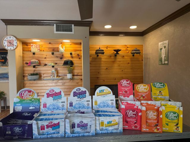 Display of assorted colorful packaged snacks or products on shelves and table in a store.