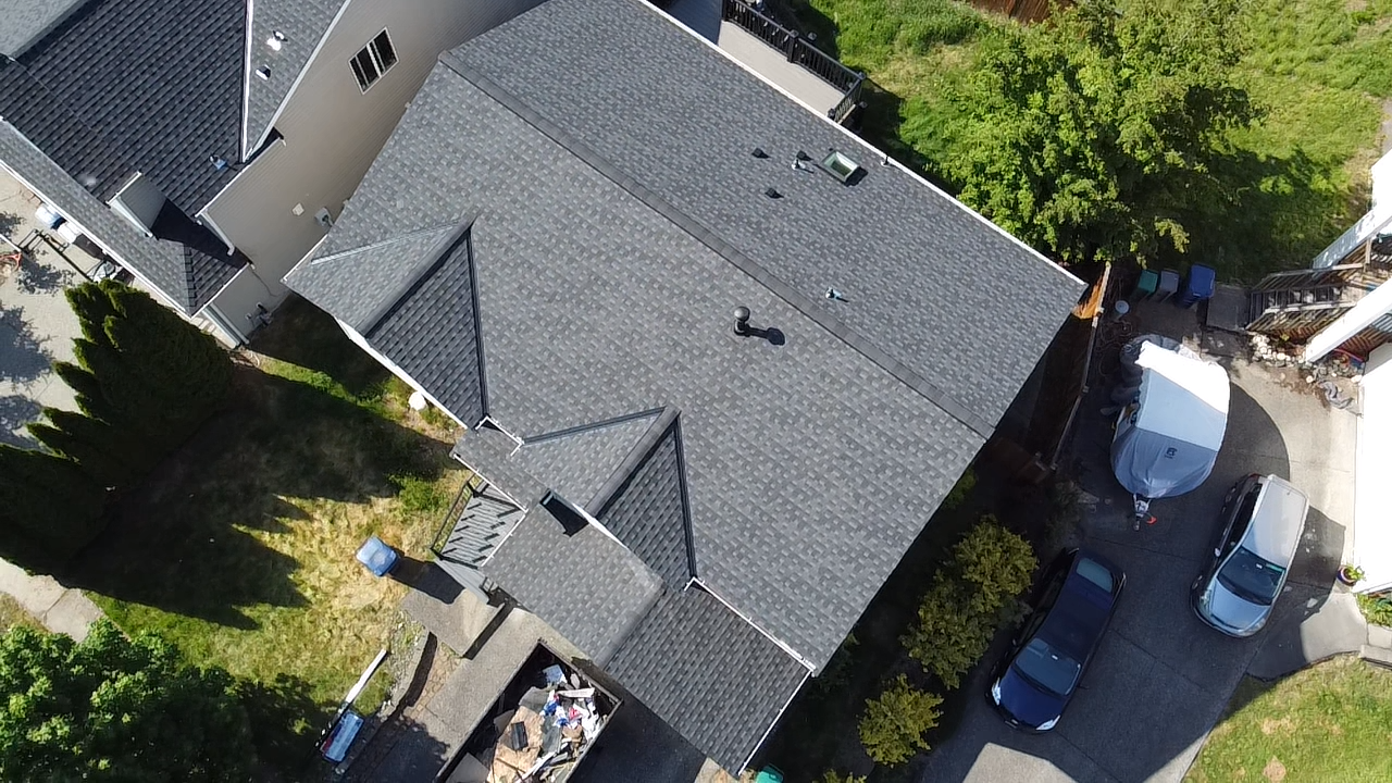 An aerial view of a house with a roof that is being repaired.
