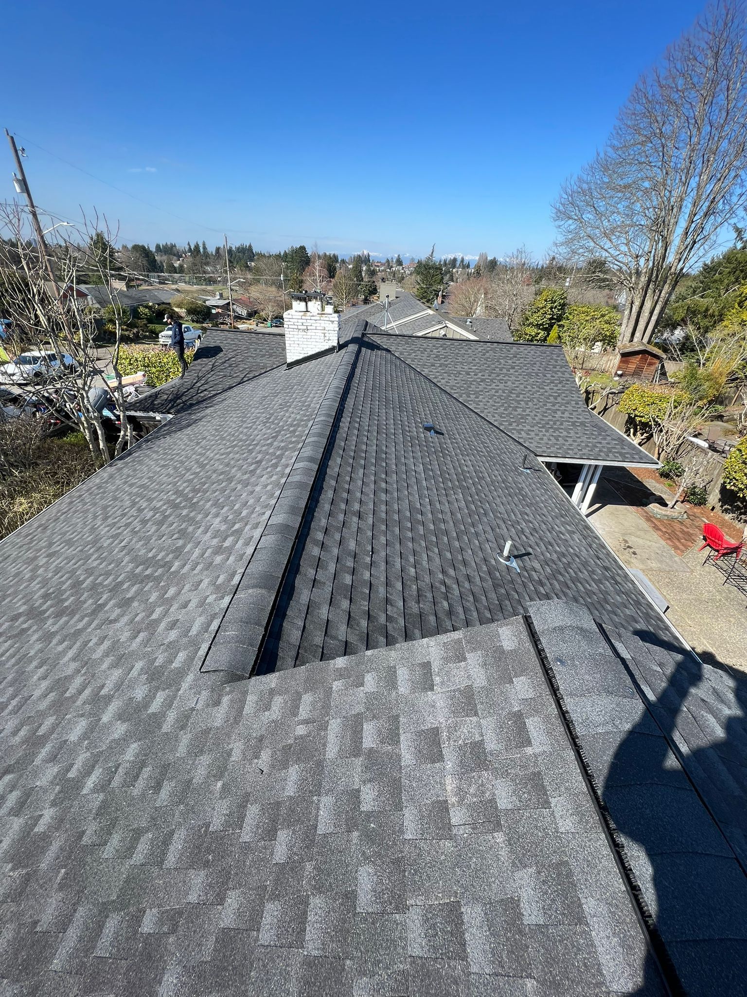 A roof with a lot of shingles on it and a chimney.