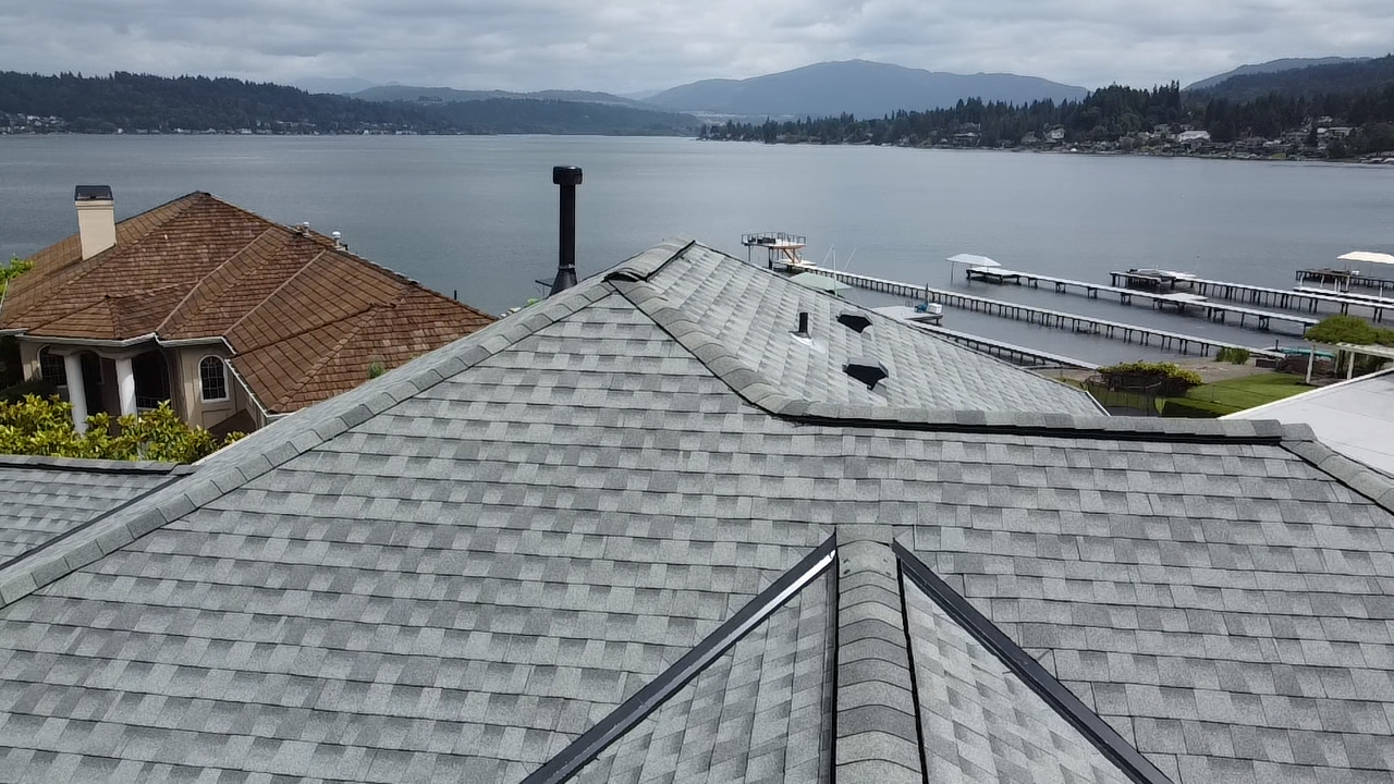 A roof with a view of a lake and mountains