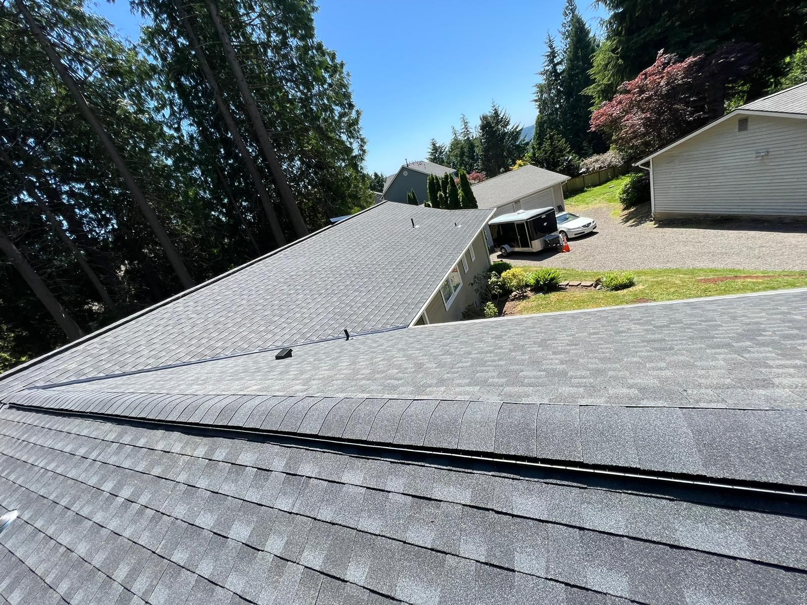 A roof with a lot of shingles on it is surrounded by trees.