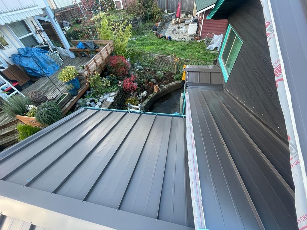 An aerial view of a roof of a house with a garden in the background.