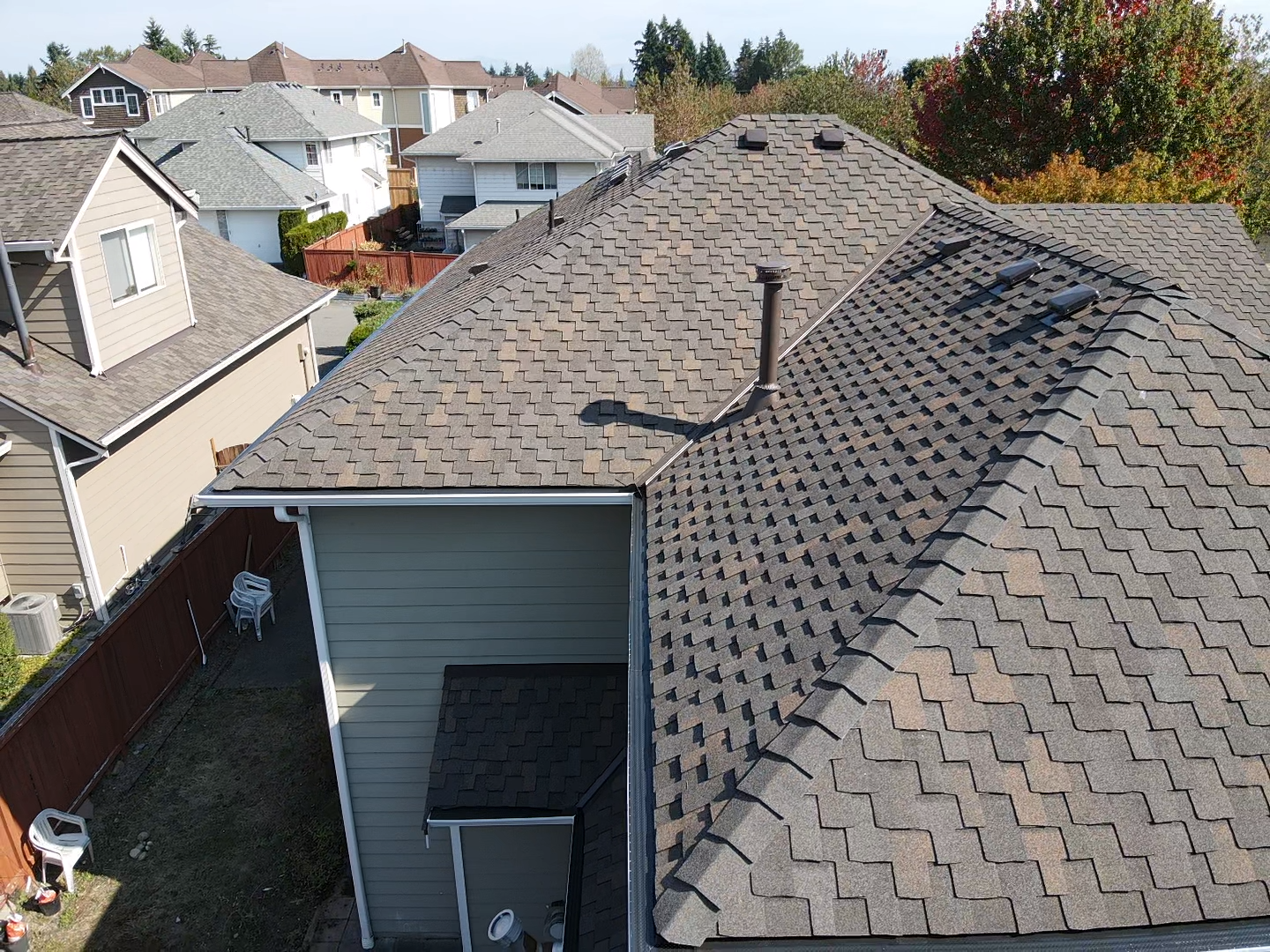 An aerial view of a roof of a house in a residential area