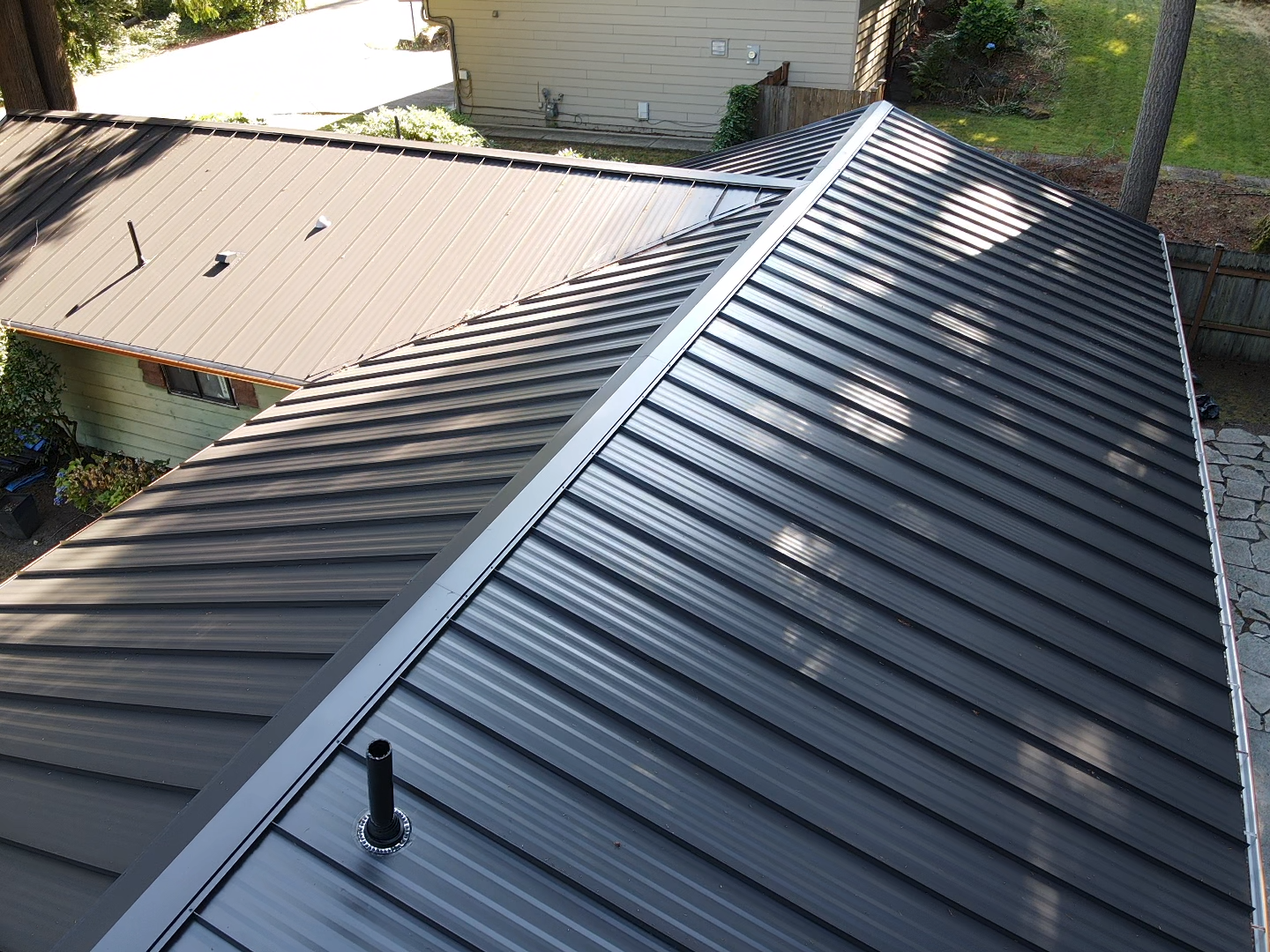 The roof of a house with a black metal roof