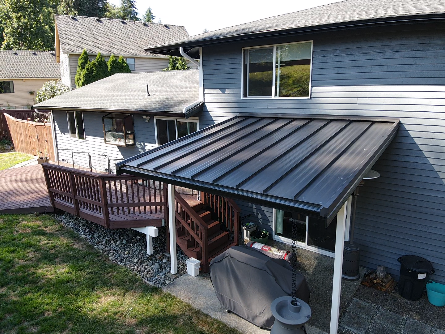 A house with a black roof and a wooden deck