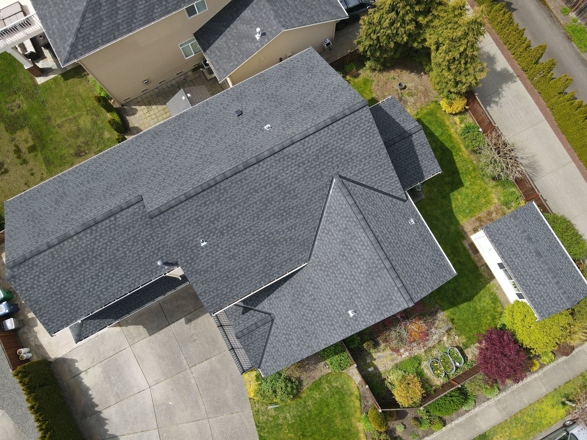 An aerial view of a house with a roof and a driveway.