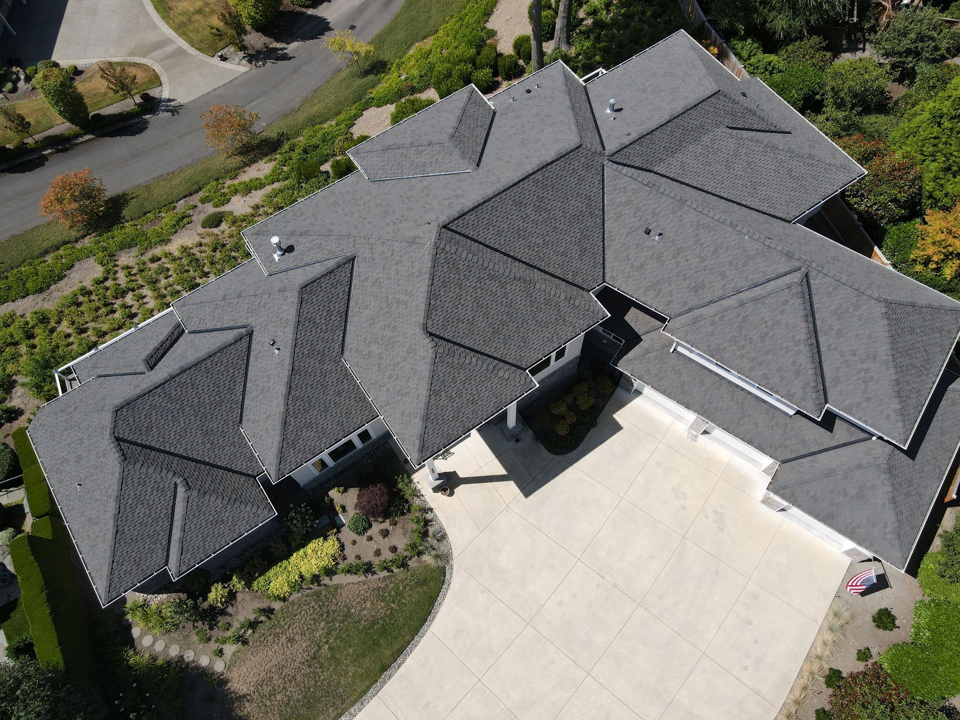 An aerial view of a large house with a gray roof